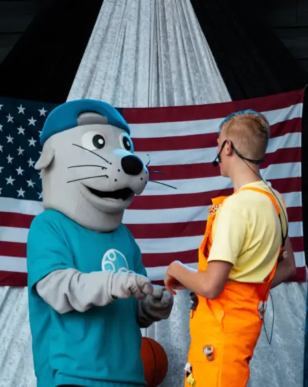 Twee vrienden, één geheimpje? Wizzl en zijn maatje overleggen terwijl de show doorgaat