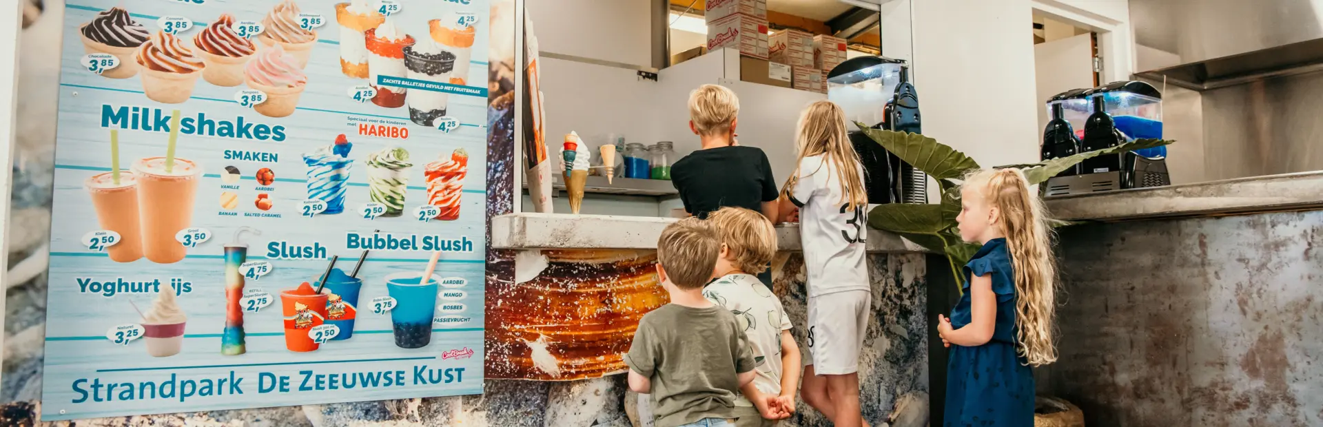 Met de voetjes in de zandkleurige vloer en een verlangende blik op het menu – genieten begint hier bij het familieresort in Zeeland